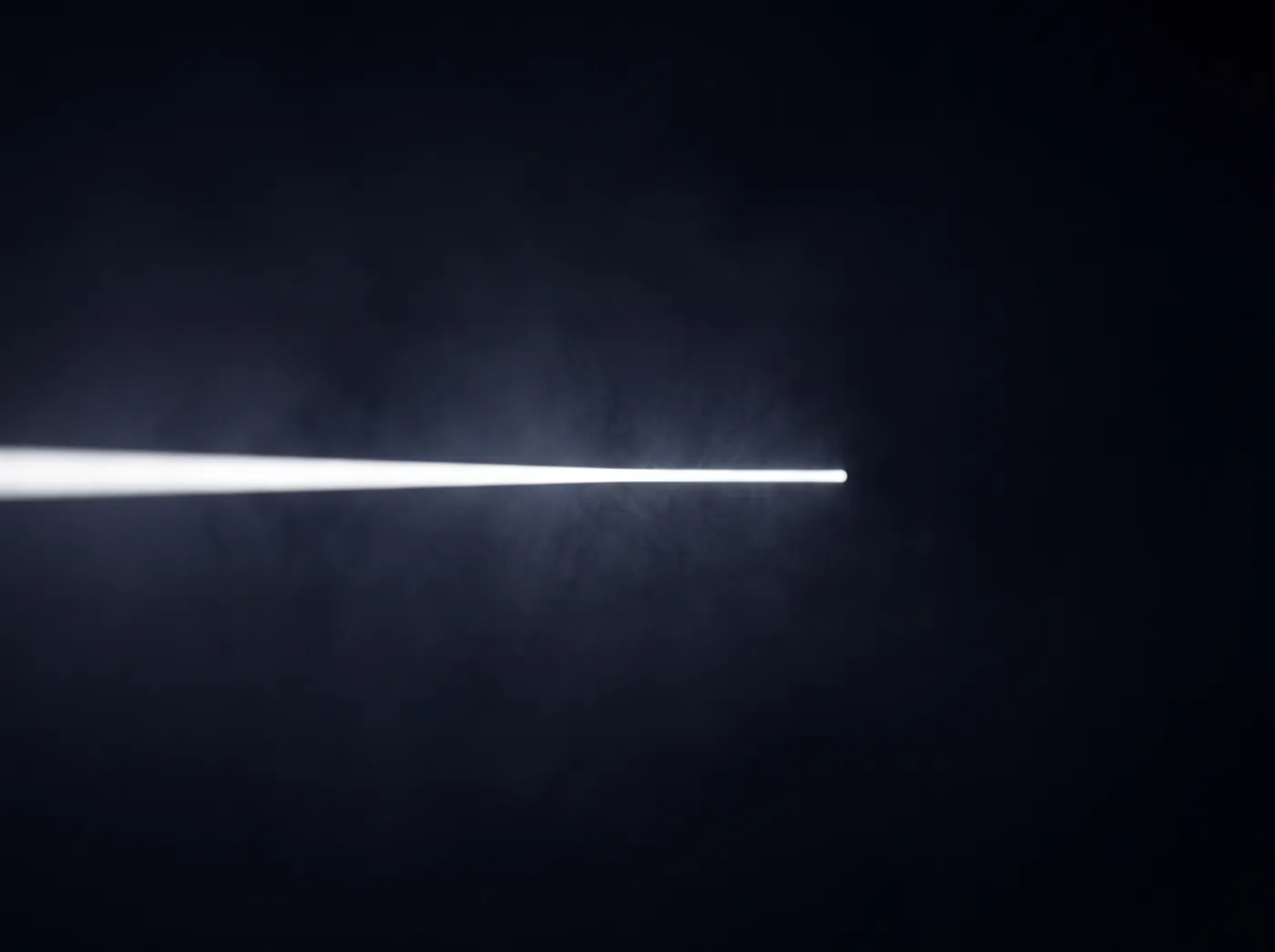 A single beam of white light travelling through darkness, not yet refracted